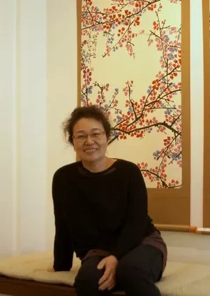 photo portrait artiste peintre Choé Joo-Young devant ses oeuvres dans son atelier-galerie